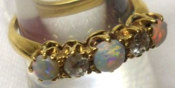 A high grade precious metal three circular Opal and two small Old Cut Diamond Ring, stamped “18ct”