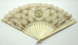 A late 19th/early 20th Century Fan, the ivory sticks carved with scrolls and foliage and with a silk