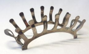 A George VI Novelty Six Slice Toast Rack of “bridge” form, with comb-shaped sides and end carrying