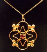 An Edwardian period 9ct Gold Openwork Pendant, set to the centre with a red stone, stamped “9ct”,