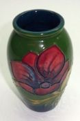 A Moorcroft Small Baluster Vase, decorated with an anemone design on a green ground, base with paper