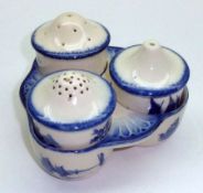 A Royal Doulton “Norfolk” pattern Four Piece China Cruet, typically decorated in blue (chips,