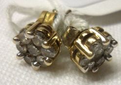 A pair of 9ct Gold all Diamond set Stud Earrings, each featuring seven small Brilliant Cut Diamonds