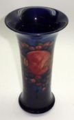 A Moorcroft Trumpet Vase, decorated with a pomegranate pattern on a blue ground, impressed marks and