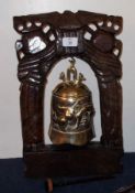 An Oriental Brass Reproduction Temple Bell, in a hardwood frame, with striker, 17” high