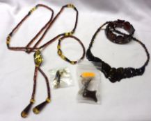 A Long Amber Pendant Tie; together with a pair of matching Earrings; and a Rich (Cherry) Amber