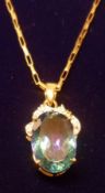 A yellow metal framed oval Mystic Quartz Pendant with small Diamond mount, stamped “9ct” and mounted