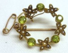 An Edwardian period mid-grade yellow metal Circular Open Centre Brooch set with five Peridots and