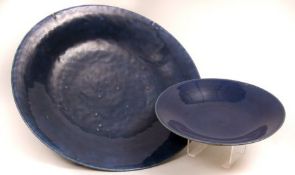 An Oriental Blue Glaze Charger; a further similar smaller Dish, both of circular form, in plain
