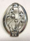 A boxed reproduction Rennie Mackintosh style white metal Brooch, pierced with an Art Nouveau