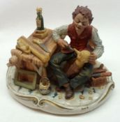 A Naples (Capodimonte) Model of a woodcarver seated with tools of his trade by a bench, 7” high