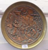 A Circular Brass Framed and Copper Wall Plaque, depicting a Roman scene, 12” diameter
