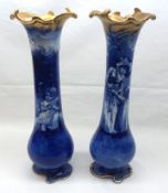 A pair of Royal Doulton Spill Vases, each printed in blue with scenes of a child with a doll