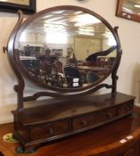 A Mahogany Large Toilet Mirror with oval mirror back, raised on a bowed base fitted with three
