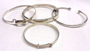 A packet of four assorted Silver/white metal Bangles, one stamped “Tiffany & Co” (4)