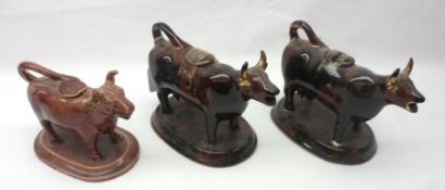 A collection of three Staffordshire treacle glazed Cow Creamers, two with gilded horns (all with