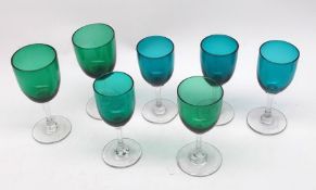 A collection of seven green bowled Wine Glasses with clear stems and spreading circular bases, (