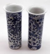 Two small Oriental Trumpet Vases, each painted in under glazed blue with dragons amidst foliage, (