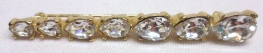 A Christian Dior gilt metal Dress Brooch, set with seven graduated teardrop-shaped white stones in