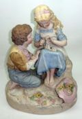 A large European Painted Biscuit Porcelain Group of boy and girl, decorated predominantly in puce,