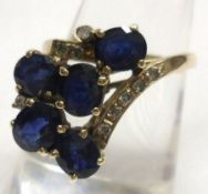 A high grade precious metal Dress Ring featuring a crossover design of five mid blue Sapphires and