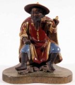 An usual (possibly Korean) Pottery Figure of a seated Oriental wearing a wide brimmed hat and with a