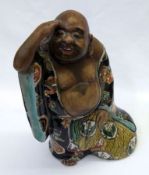 An Oriental Model of a Portly Man, his robe ornately decorated on a predominantly famille noir