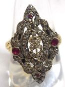 An unmarked precious metal Ring, with marquise-shaped panel, pierced and inset with small Rubies and