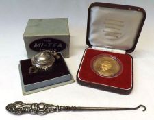 A Mixed Lot:  Embossed Silver handled Button Hook, boxed plated “Teapot” formed Tea Infuser and