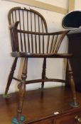 An Oak Windsor style Stick Back Armchair, with solid seat, splayed legs joined by a crinoline