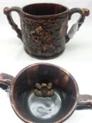 A Staffordshire treacle glazed two-handled circular Loving Cup, the outer body embossed with