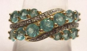 A hallmarked 9ct Gold Dress Ring, set with three bands of blue Apatite Stones in crossover style