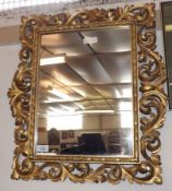 A Decorative Giltwood Rectangular Wall Mirror, the frame elaborately carved with foliate scrolls,