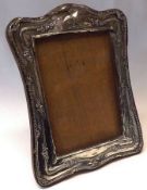 A George V Silver mounted Photograph Frame of shaped rectangular form, wooden easel back,