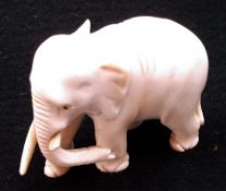 An Oriental or Indian Ivory Model of an elephant (part of one tusk missing), 2 ½” high