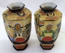 A pair of 20th Century Satsuma Vases of octagonal baluster form, decorated in heavy palette with