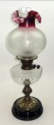 A Victorian and later Oil Lamp, with opaque shade and puce tinted crimped rim, clear glass font,