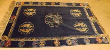 A Chinese Wool Rug decorated with lozenge-type stylised floral panels on a mainly green and blue