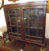 A small Mahogany Bookcase Cabinet with glazed front enclosing fitted shelving on bracket feet, 31”