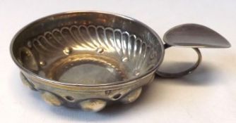 A French white metal Wine Taster of usual form, embossed and fluted decoration, plain oval thumb