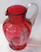 A Cranberry Glass Jug with reeded clear looped handle, painted in the manner of Mary Gregory with