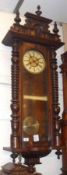 A late 19th Century Walnut Cased Vienna type Wall Clock, the overhanging cornice surmounted by a