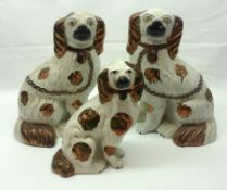 A pair of Staffordshire Models of seated Dogs, each with gilded body markings, naturalistic faces