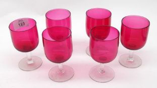 A set of six Cranberry bowled small stemmed Wine Glasses, with clear stems and feet, 20th Century,