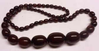 A long row of dark red Amber type Beads