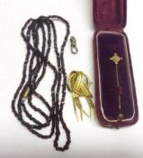 A Mixed Lot of facetted Garnet Bead Necklace; gilt metal tassel Brooch and a Cased Stick Pin (2)