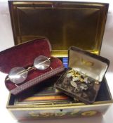 A metal tin containing a quantity of Costume Jewellery, including Brooches, Pearl type Necklet, gilt