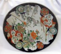 An Imari circular Charger, painted in typical colours with a central scene of a leaping dog of Fo