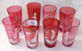 A collection of eight various Cranberry Beakers, all decorated in the manner of Mary Gregory with