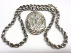 An oval white metal Locket chased with a cross and mounted on a rope twist chain